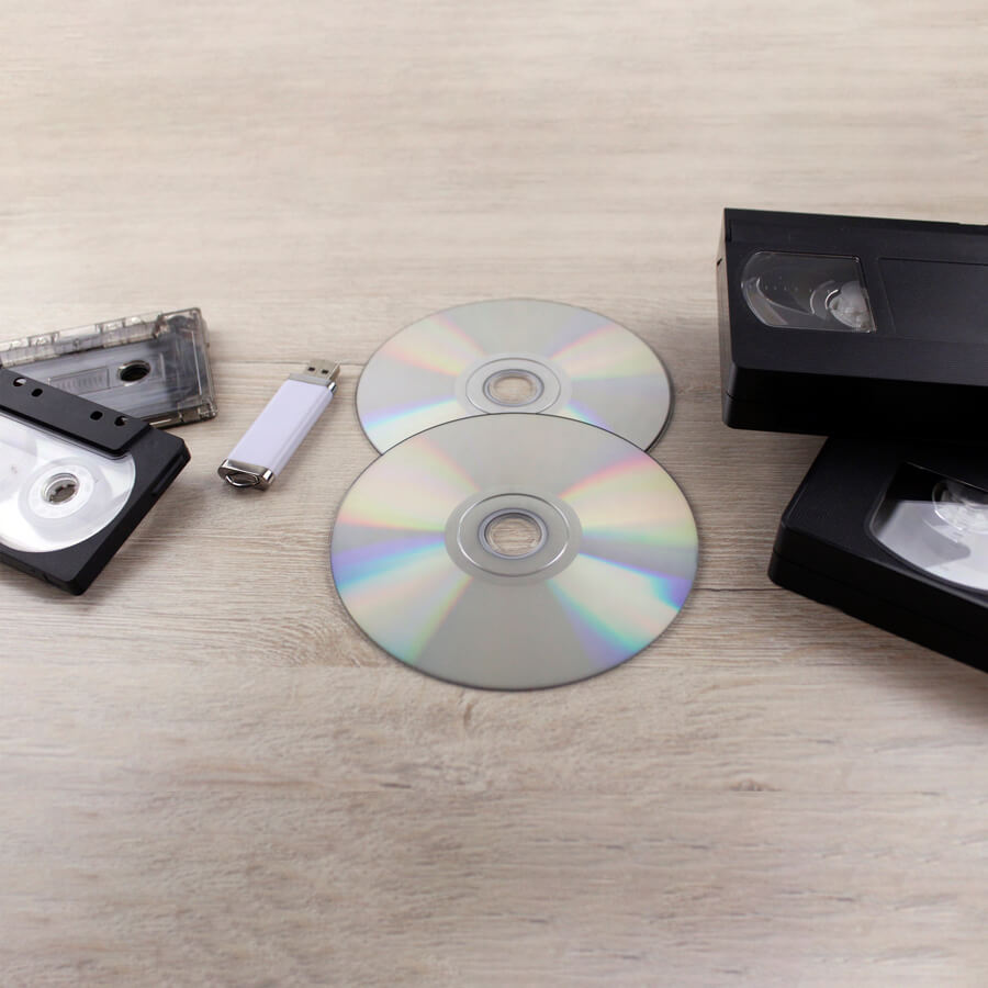 A selection of digital media including cassettes, data tapes, VHS, CDs and memory stick.